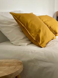 - un oreiller jaune assis au-dessus du lit dans l'établissement Charmant studio proche RER B direction Paris, à Fontenay-aux-Roses