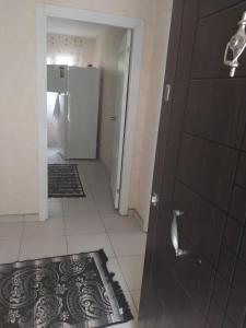a bathroom with a brown door and a tile floor at VİLLAGE GARDEN APART in Kemer