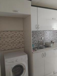 a kitchen with a washing machine and a sink at VİLLAGE GARDEN APART in Kemer