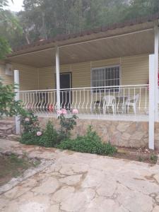 a house with a white porch with chairs on it at VİLLAGE GARDEN APART in Kemer