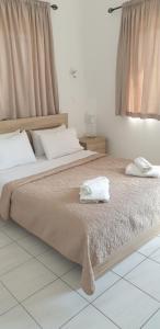 um quarto com uma cama grande com duas toalhas em GEORGE & ELENA APARTMENTS em Amoudara Herakliou