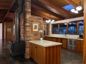 a kitchen with a brick wall and a stove at Wandjoo Cottage Cranbourne in Lyndhurst South