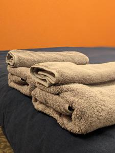 una pila de toallas sentadas encima de una cama en Tbox, en Kutchan