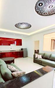 een woonkamer met een groene bank en rode kasten bij Agadir chez Omar in Agadir