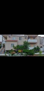 a view of a building with plants in front of it at Apartments Golić in Biograd na Moru