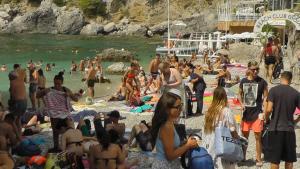 a large group of people on a beach at Capri room on the beach in Capri