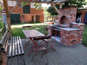 a patio with a table and a brick oven at Shropshire House in Groß Leppin