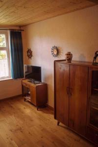 uma sala de estar com uma televisão e um armário de madeira em Shropshire House 