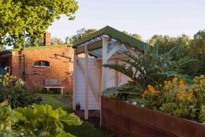 um galpão branco com um telhado verde num jardim em Shropshire House 