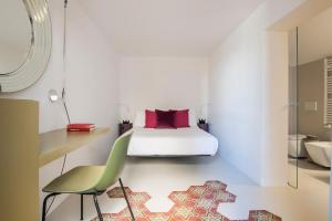 a bedroom with a bed and a green chair at Dimora Talenti in Polignano a Mare