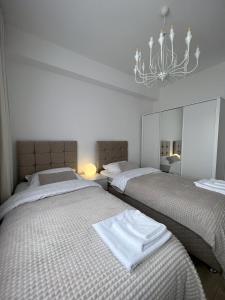 a bedroom with two beds and a chandelier at Modern, City/Industrial Style in Ferizaj