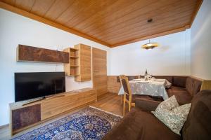 a living room with a couch and a tv and a table at Apartment Brunelle in Selva di Val Gardena