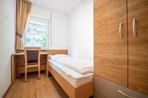 a bedroom with a bed and a desk and a window at Apartment Brunelle in Selva di Val Gardena