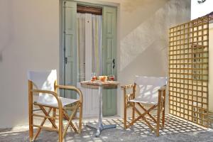 a table and chairs on a porch with a door at Doma-Stafylos 2 in Skopelos Town