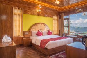 ein Schlafzimmer mit einem großen Bett mit gelber Wand in der Unterkunft Wood Crista Kufri near an Apple Orchard in Kūfrī