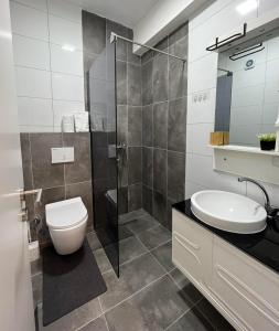 a bathroom with a toilet and a sink and a shower at Modern, City/Industrial Style in Ferizaj