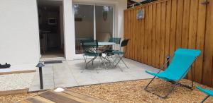 a patio with chairs and a table in a yard at La Petite Perle in Andernos-les-Bains +4 photos