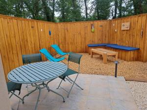 a patio with a table and chairs and a bench at La Petite Perle in Andernos-les-Bains