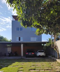 uma casa com dois carros estacionados na garagem em Ed Bertholi - Vista lateral do mar com garagem em Serra