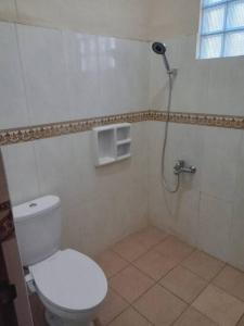 La salle de bains est pourvue d'une douche et de toilettes. dans l'établissement Amason Homestay, à Yogyakarta