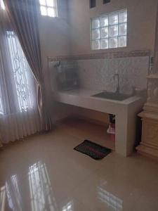 Elle comprend une petite salle de bains pourvue d'un lavabo et d'une fenêtre. dans l'établissement Amason Homestay, à Yogyakarta