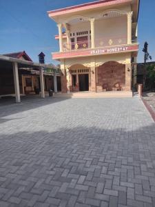 - un grand bâtiment avec une terrasse en briques devant dans l'établissement Amason Homestay, à Yogyakarta