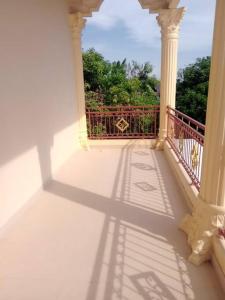 un balcon à l'ombre d'une clôture et d'arbres dans l'établissement Amason Homestay, à Yogyakarta