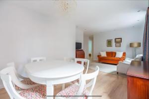 una mesa blanca y sillas en la sala de estar. en COSY Apartment AREETA STATION las Arenas Getxo, en Getxo