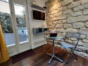 a table and chair in a room with a stone wall at Romantic tiny house in Montmartre in Paris