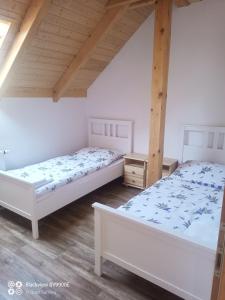 two beds in a room with wooden ceilings at Chalupa Kozí 62 in Klatovy