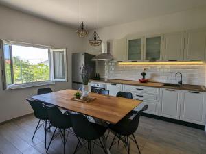 a kitchen with a wooden table and chairs at Runaway Cottage in Unešić