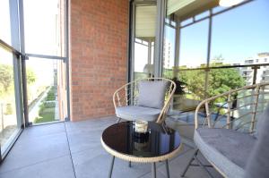 a balcony with a chair and a table and some windows at Green Estate Old Town Apartment, private parking, balcony in Gdańsk