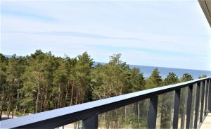 a balcony with trees and the ocean in the background at ApartamentyRogowo Com in Rogowo