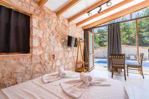 a bedroom with a bed and a stone wall at Casa De Sherys in Kas