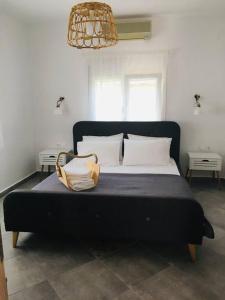 a black bed with white pillows and a purse on it at Babushka Apartments in Olympiada