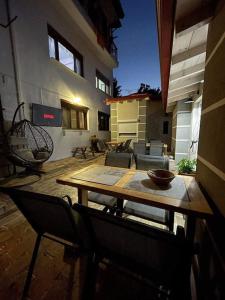 een houten tafel en stoelen op een patio bij Babushka Apartments in Olympiada