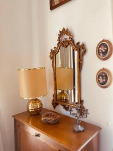 een tafel met twee lampen en een spiegel erop bij Appartamento retrò-chic in La Spezia in La Spezia