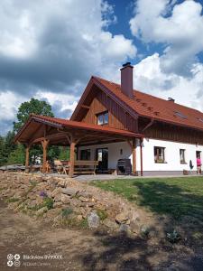 ein großes weißes Haus mit Holzdach in der Unterkunft Chalupa Kozí 62 in Klatovy