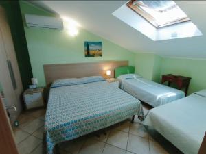 Cette petite chambre comprend deux lits et une lucarne. dans l'établissement B&B Villa Maria Paola - Alloggi Temporanei Isernia, à Isernia