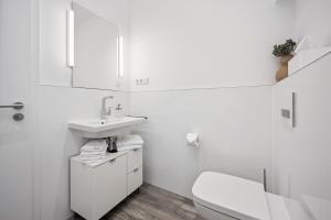 uma casa de banho branca com um WC e um lavatório em Park Avenue Apartments I Domsuite I Hbf I Netflix I WLAN em Colônia