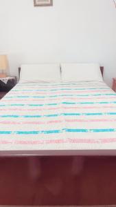 een bed met een gestreepte deken erop bij Villa Maria (3) in Gardeládes