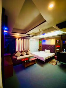 HOTEL BLUE BIRD في داكا: غرفة نوم بسرير واريكة في غرفة
