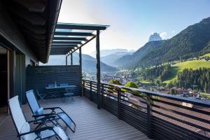 balcone con 2 sedie, tavolo e montagne di Villa Mayr a Ortisei
