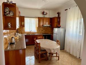 eine Küche mit einem Tisch und einem Kühlschrank in der Unterkunft Vila Sidi in Ksamil