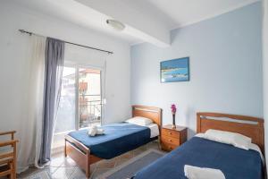 1 dormitorio con 2 camas y ventana en Erifili House, en Kallithea Halkidikis