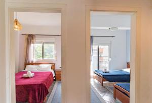 um quarto com uma cama com um cobertor vermelho em Erifili House em Kallithea Halkidikis