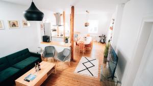 a living room with a green couch and a table at 4-Schlafzimmer-Terrassensuite Oasis - WORKSPACE EM-APARTMENTS DEUTSCHLAND in Bielefeld