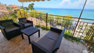 einen Balkon mit Stühlen und Tischen sowie Meerblick in der Unterkunft BeachHouse in Arkondikó