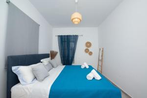 a blue and white bed in a white room at Vaqueros in Mikonos