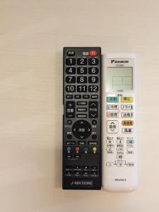 un mando a distancia y una calculadora sentados uno al lado del otro en Tbox, en Kutchan